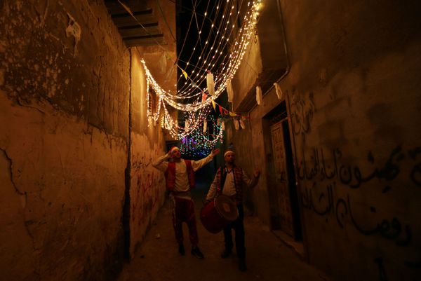 Palestinian Musharatis call for Muslims to wake up to have the predawn meal before they start their long-day fast, on the first day of the holy month of Ramadan, amid concerns about the spread of the coronavirus disease (COVID-19), in Rafah - Sputnik Азербайджан