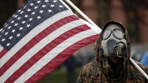 Человек в защитном костюме с флагом США - Sputnik Азербайджан