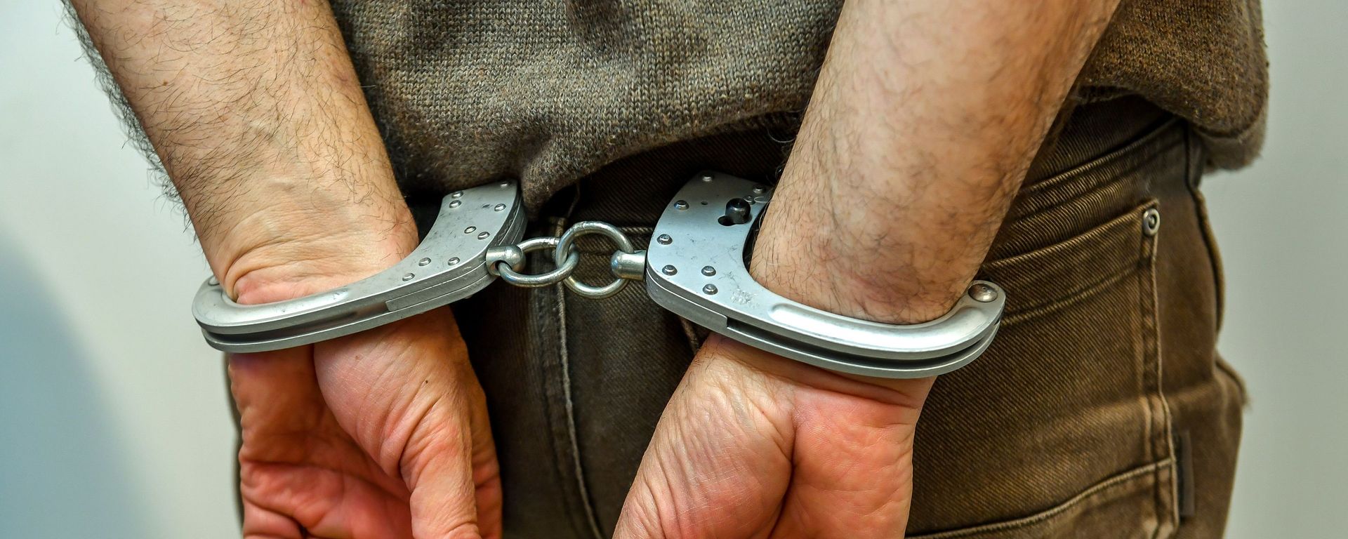 Мужчина в наручниках в полицейском участке, фото из архива - Sputnik Азербайджан, 1920, 20.04.2023
