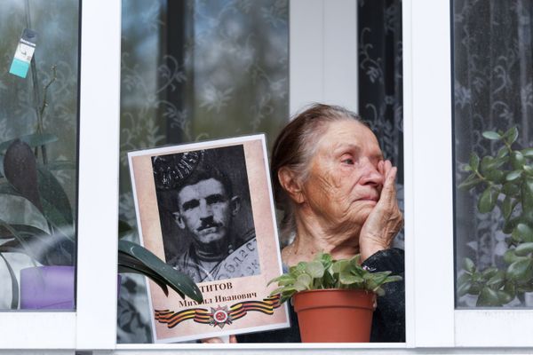 Жительница Иркутска на балконе с портретом своего родственника - ветерана Великой Отечественной войны в рамках акции Окна Победы - Sputnik Азербайджан